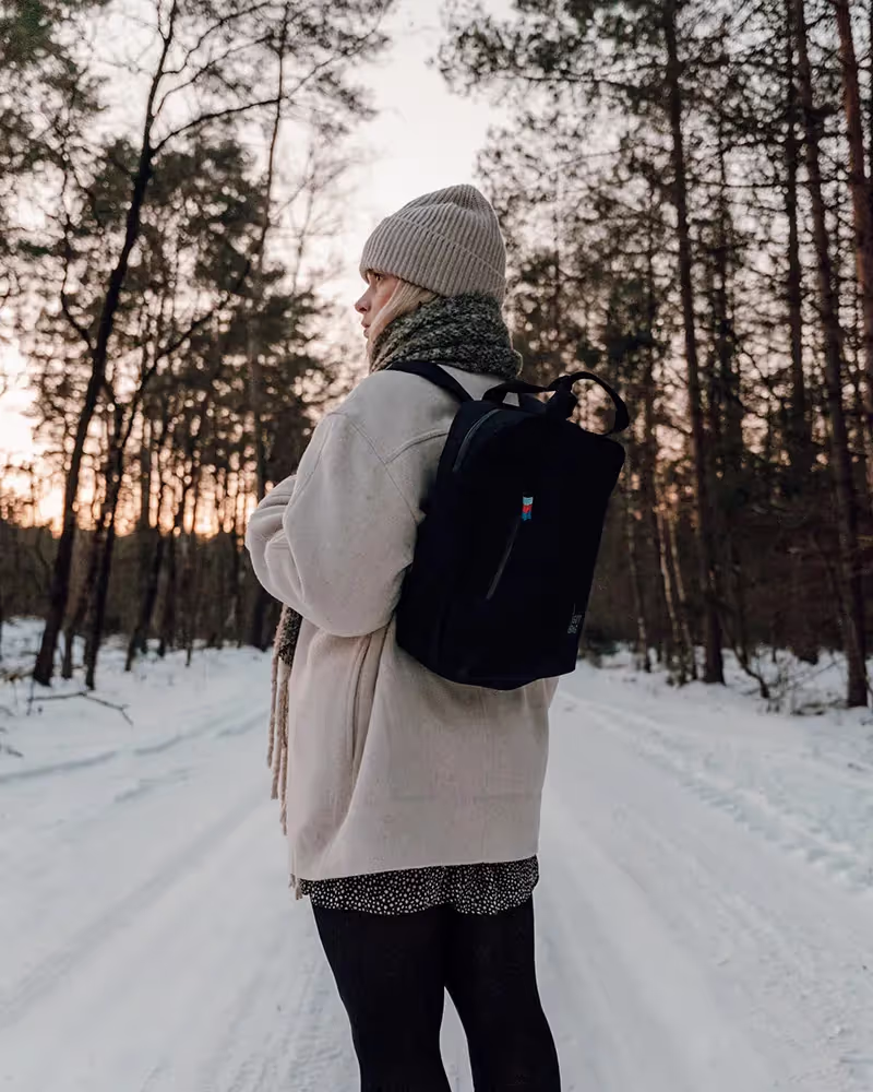 Eine Frau geht eine schneebedeckte Straße entlang.